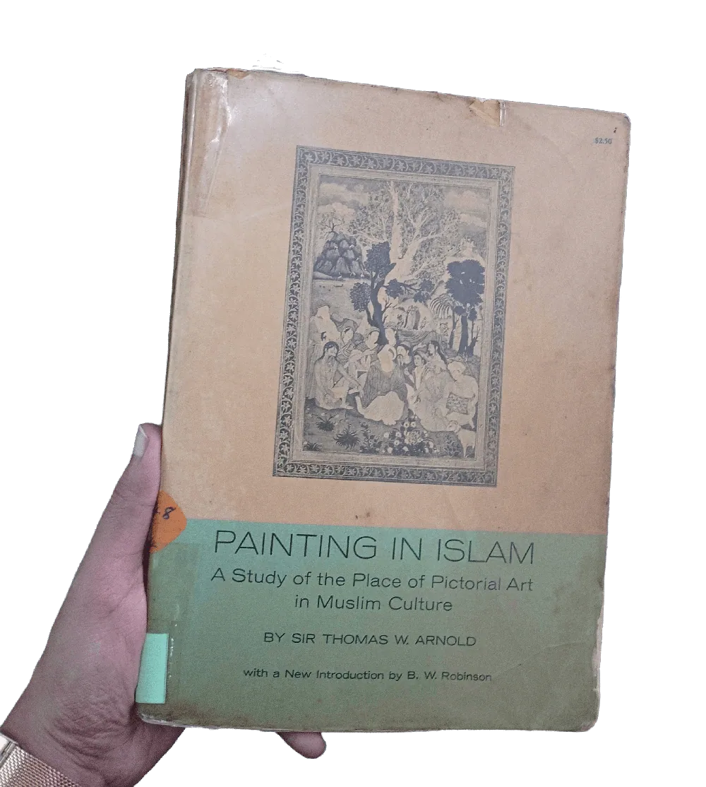 Original book cover held in hand